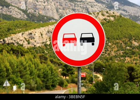 Panneau - le dépassement est interdit, sur la belle route de montagne en Croatie. Pas de dépassement. Panneaux routiers interdisant les voitures particulières Banque D'Images