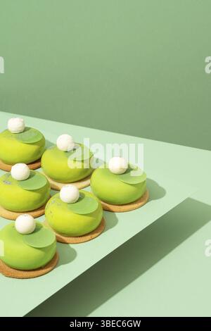 Un plateau de beignets verts assortis est posé sur une table en bois Banque D'Images