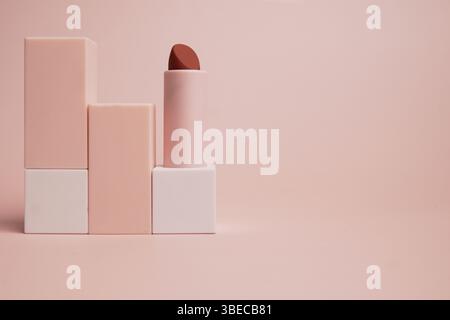 rouge à lèvres reposant l'un sur l'autre sur un fond rose Banque D'Images