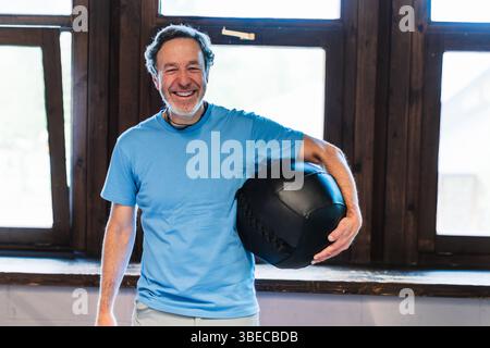 Un homme tient une boule noire dans sa main et souriant concept de bonheur et de positivité Banque D'Images