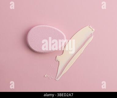 L'éponge cosmétique en forme d'œuf sur fond rose. Vue de dessus Banque D'Images