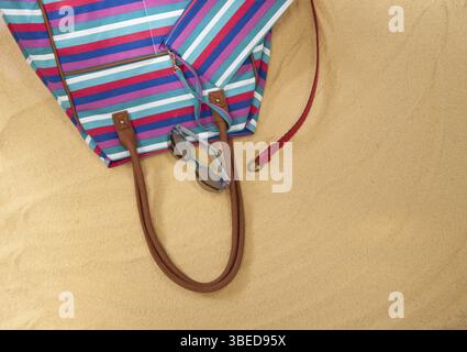 Un ensemble de vêtements d'été lumineux pour la plage sur le sable doré. le concept de la saison estivale et des loisirs. vue de dessus Banque D'Images