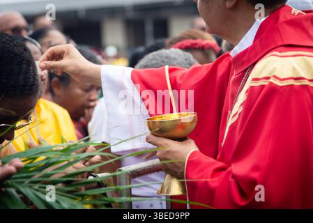 Salvador, Bahia, Brésil - 13 avril 2025 : les prêtres catholiques distribuent des gaufrettes de communion aux fidèles le dimanche des Rameaux à Salvador, Brésil Banque D'Images