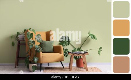 Fauteuil, table et plantes d'intérieur près du mur vert dans la chambre. Différents motifs de couleur Banque D'Images