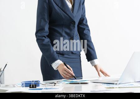 Femme d'affaires debout près du bureau avec ordinateur portable et documents. Audit et conseil financiers. Directeur d'entreprise en costume travaillant avec le bus en ligne Banque D'Images