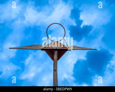 Photographie regardant à travers un vieux ring de basket-ball rouillé contre un ciel bleu vif dans la région de l'Australie. Banque D'Images