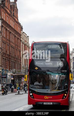 Un bus à impériale rouge se rend à Russell Square à Londres, en passant devant des bâtiments historiques en briques. Banque D'Images