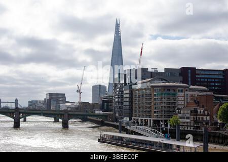 Vue sur le Shard surplombant la Tamise à Londres, entouré de bâtiments modernes et de grues. Banque D'Images