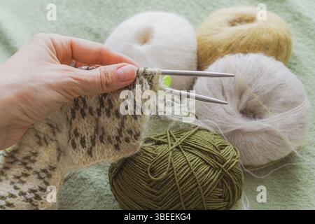 Aiguilles à tricoter dans la main d une femme. Articles tricotés. Chaussettes chaudes faites maison. Motif de couture. Fil de laine de qualité. Vêtements d'hiver. Cadeau de Noël. Banque D'Images