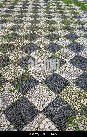 Pavé portugais traditionnel avec motif en pierre noire et blanche. Calcada Portuguesa Mosaic Design, pavage de rue historique, carré géométrique Banque D'Images