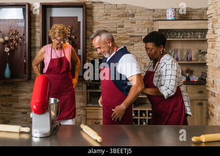 Chefs portant des tabliers se préparant pour le cours de cuisine Banque D'Images