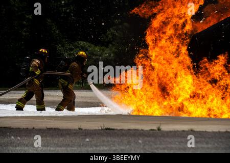 Les pompiers affectés à la 628th Air base Wing mènent une démonstration de tir réel à joint base Charleston, Caroline du Sud, le 22 mai 2025. Le démoniaque Banque D'Images