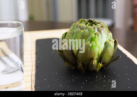 Artichauts cuits sur planche de pierre noire Banque D'Images