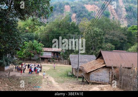 Un grand groupe de touristes en visite dirigé par un guide prenant une courte visite autour du village de Ban Paksit, un petit village isolé sur le fleuve Mékong dans le nord Banque D'Images