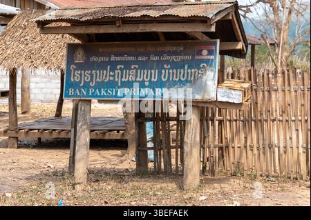 Un grand panneau de village de la tribu Khmu Hill avec le nom de l'école et du village, 'Ban Paksit Primary,' Ban Paksit village est un petit village isolé sur th Banque D'Images