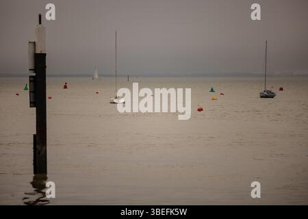 Voiliers et bouées de navigation dans le Solent au large de l'île de Wight par un après-midi d'hiver brumeux. Utilisation éditoriale uniquement en raison de restrictions de propriété. Banque D'Images
