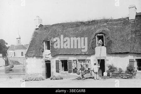 Cette photographie des environs de 1910, prise par le Touring-Club de France, montre un chalet au toit de chaume à Penmarc'h, en Bretagne. L'image offre un regard sur l'architecture rurale et le mode de vie dans la France du début du XXe siècle. Banque D'Images