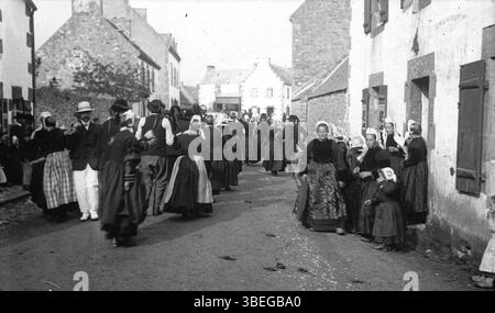 Cette photographie du début du XXe siècle montre le *pardon* à Quimperlé, en Bretagne, pris vers 1910. La fête religieuse, une coutume bretonne traditionnelle, est décrite comme un événement culturel important pour la communauté de Quimperlé pendant cette période. Banque D'Images