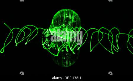 Orbe de verre incandescent avec des lumières laser qui le traversent Banque D'Images