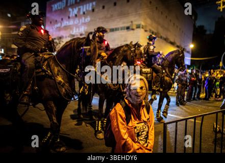 Tel Aviv, Israël. 28 mai 2025. Une femme portant un masque représentant Sarah Netanyahu, épouse du premier ministre israélien Benjamin Netanyahu, se tient aux côtés de policiers montés à cheval lors d’une manifestation à côté du siège du Likoud au pouvoir à tel Aviv, appelant le premier ministre israélien Benjamin Netanyahu à mettre fin à la guerre à Gaza et à signer un accord de libération d’otages, mercredi 28 2025 mai. Crédit : Eyal Warshavsky/Alamy Live News Banque D'Images
