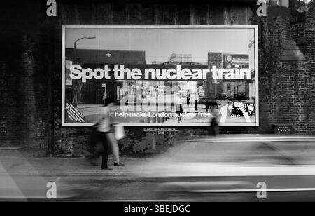 Une affiche du GLC « Aidez Londres à libérer du nucléaire » sous un pont de chemin de fer dans une rue de Londres. L'affiche, l'une des quatre photographies de Martin Bond de trains nucléaires à Londres, a été produite par le GLC en 1983 pour coïncider avec l'enquête publique Sizewell 'B'. La photo montre une fiole nucléaire sur la North London Line traversant Caledonian Road, Londres N1. Banque D'Images