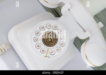 Un élégant téléphone à bouton-poussoir d'inspiration rétro conçu pour reproduire l'esthétique classique des téléphones à cadran rotatif vintage, téléphone blanc Banque D'Images