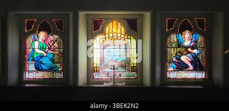 Les trois panneaux inférieurs de la fenêtre du mémorial William Breese à l'église épiscopale Mary's-in-Tuxedo de Tiffany & Co. mettent en valeur l'art complexe des vitraux qui définit l'héritage de Tiffany dans les monuments commémoratifs de l'église. Banque D'Images