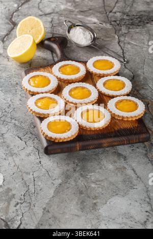 Les cookies combinent deux couches de biscuits Shortbread au beurre et un gros plan de remplissage de citron acidulé fait maison sur une planche de bois sur la table. Vertical Banque D'Images
