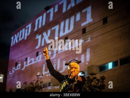 Un manifestant portant un masque représentant le premier ministre israélien Benjamin Netanyahu montre une projection qui lit en hébreu « L'ambassade du Qatar en Israël » pendant la manifestation à côté du siège du Likoud au pouvoir, appelant le premier ministre israélien Benjamin Netanyahu à mettre fin à la guerre à Gaza et à signer un accord de libération des otages. Six cent et un jours après le début de la guerre le 7 octobre 2023, un nouvel accord américain de l’envoyé spécial Steve Witkoff verrait 10 otages israéliens vivants libérés et les corps de 18 personnes décédées retournés de Gaza en échange d’un cessez-le-feu de 60 jours, pourtant la droite gagnante Banque D'Images