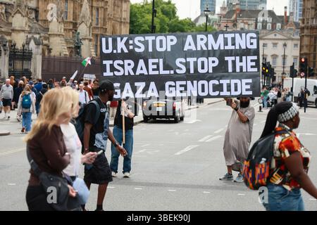 LONDRES, ROYAUME-UNI. 29 mai 2025. Deux manifestants tiennent un panneau d'affichage géant sur lequel on peut lire "génocide de Gaza". Un photographe qui prend une photo ne ment pas, mais certains éditeurs mentent sur la même photo. Un petit mensonge peut faire souffrir des millions de personnes. Ce n'est pas un blocus ; les deux manifestants prétendent bloquer la route. Ils restent sur le bord de la route et émergent lorsque le feu de circulation change en passage piéton, prétendant bloquer la route devant le Parlement, Londres, Royaume-Uni. (Photo de 李世惠/Voir Li/Picture Capital) crédit : Voir Li/Picture Capital/Alamy Live News Banque D'Images