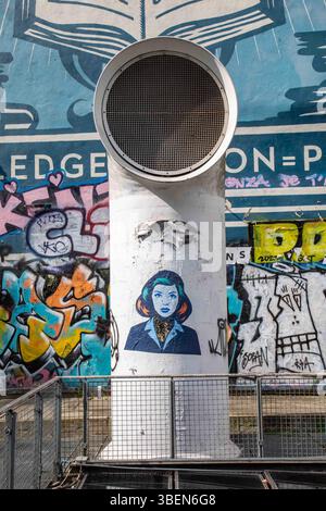 Street art parisien : affiche découpée en pâte de blé par FKDL (Frank Duval) sur le ventilateur de capot de la place Igor Stravinsky dans le quartier du Marais à Paris, France. Banque D'Images