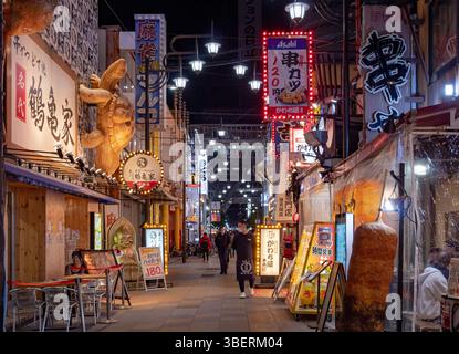 Panneaux lumineux colorés au néon le long d'une rue du quartier de Dotonbori à Osaka au Japon. Photo prise le soir la nuit Banque D'Images