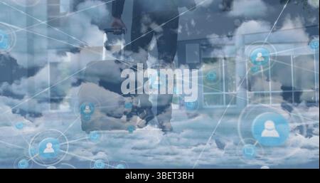 Image du réseau d'icônes de profil sur les nuages contre l'homme d'affaires marchant avec un sac à roulettes Banque D'Images