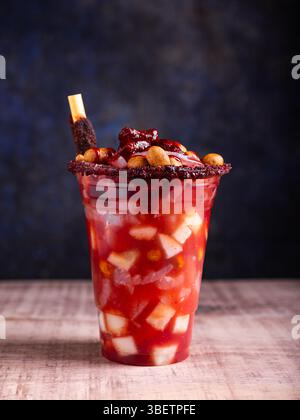 Petit verre fou, un mélange d'ingrédients sucrés, salés et épicés. Snack typique du Mexique. Banque D'Images