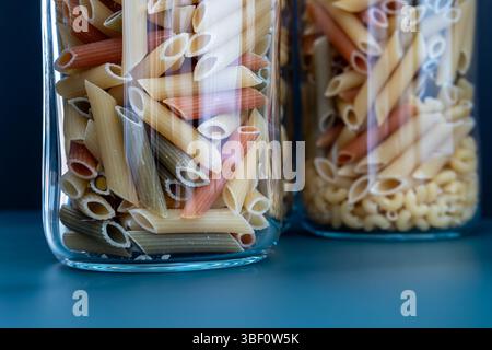 Pâtes Penne colorées dans des pots en verre Banque D'Images