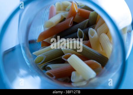 Pâtes Penne colorées dans un pot en verre Banque D'Images