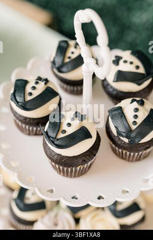 Cupcakes au chocolat décorés d'un glaçage de style smoking sur le support Banque D'Images
