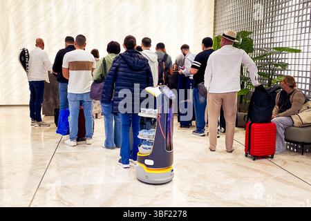 Abu Dhabi, eau - 25 avril 2025 : robot sert de l'eau à l'aéroport d'Abu Dhabi Smart Travel Experience. Client au salon de luxe. Concept Technology Serving Banque D'Images