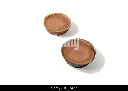 Deux tasses de beurre d'arachide l'une à côté de l'autre sur un fond blanc. Une combinaison de collation idéale de chocolat et de beurre d'arachide. Banque D'Images