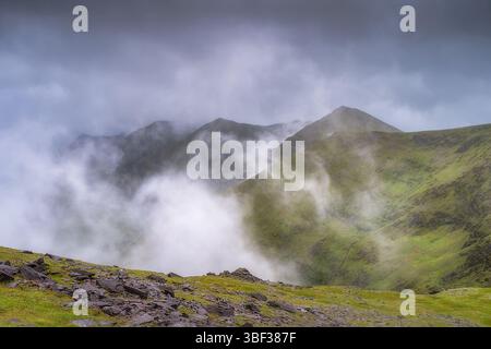 Une vue imprenable et imprenable sur la magnifique montagne Carrauntoohil brumeuse qui sont entièrement couvertes de verdure vibrante et luxuriante, créant un serein Banque D'Images