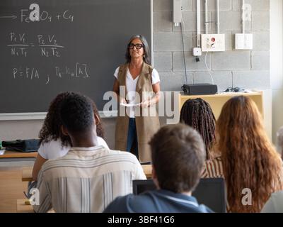 Professeur féminin enseignant les mathématiques et les sciences à divers élèves adolescents en classe Banque D'Images