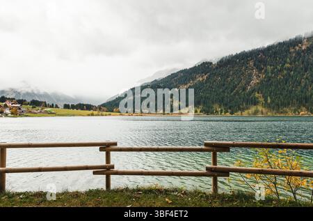 Clôture en bois autour du lac Haldensee dans le Tyrol, Autriche. Vallée alpine par un jour nuageux d'automne. Banque D'Images