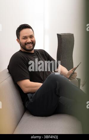 Le représentant pharmaceutique lit les informations sur les produits sur tablette dans un bureau moderne, se préparant à une visite de client de soins de santé. Banque D'Images