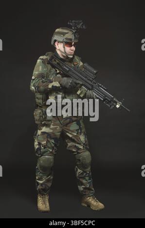Soldat de l'OTAN en pleine vitesse. Homme militaire sur fond noir Banque D'Images