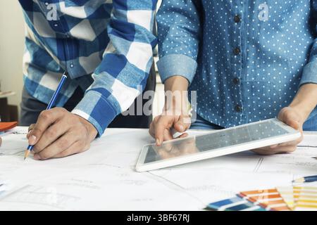 Concepteurs sélectionnant la palette de couleurs pour le projet de conception. Décorateur utilisant la tablette pour le travail. Design d'intérieur, décoration architecturale et rénovati Banque D'Images