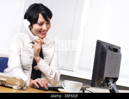 Belle femme d'affaires brune caucasienne dans son bureau Banque D'Images