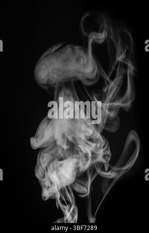 Motifs de fumée éthérée tourbillonnant gracieusement dans l'air créant un affichage visuel fascinant de fluidité et de concept de mouvement. ressource graphique pour mo Banque D'Images