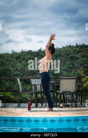 Femme faisant du yoga du matin sur une terrasse avec vue sur la montagne Banque D'Images