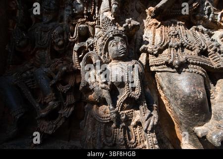Sculptures élaborées de différentes divinités ornent les murs de pierre du temple Hoysaleshwara, soulignant l'art exceptionnel et la signification historique i. Banque D'Images