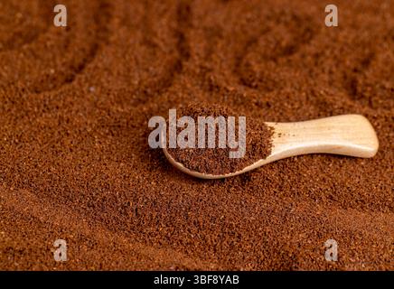 Le mot café écrit sur un café moulu pour la préparation d'une boisson, café moulu torréfié et une cuillère en bois Banque D'Images